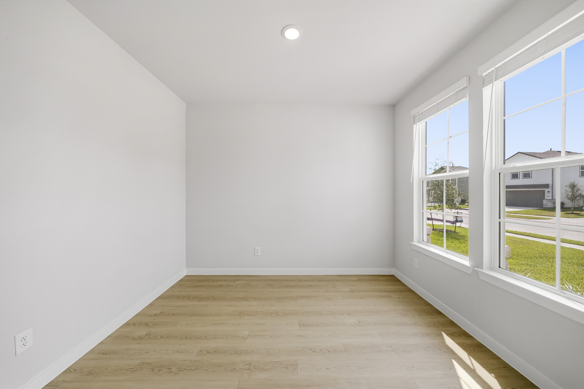 A room with windows and a wood floor.
