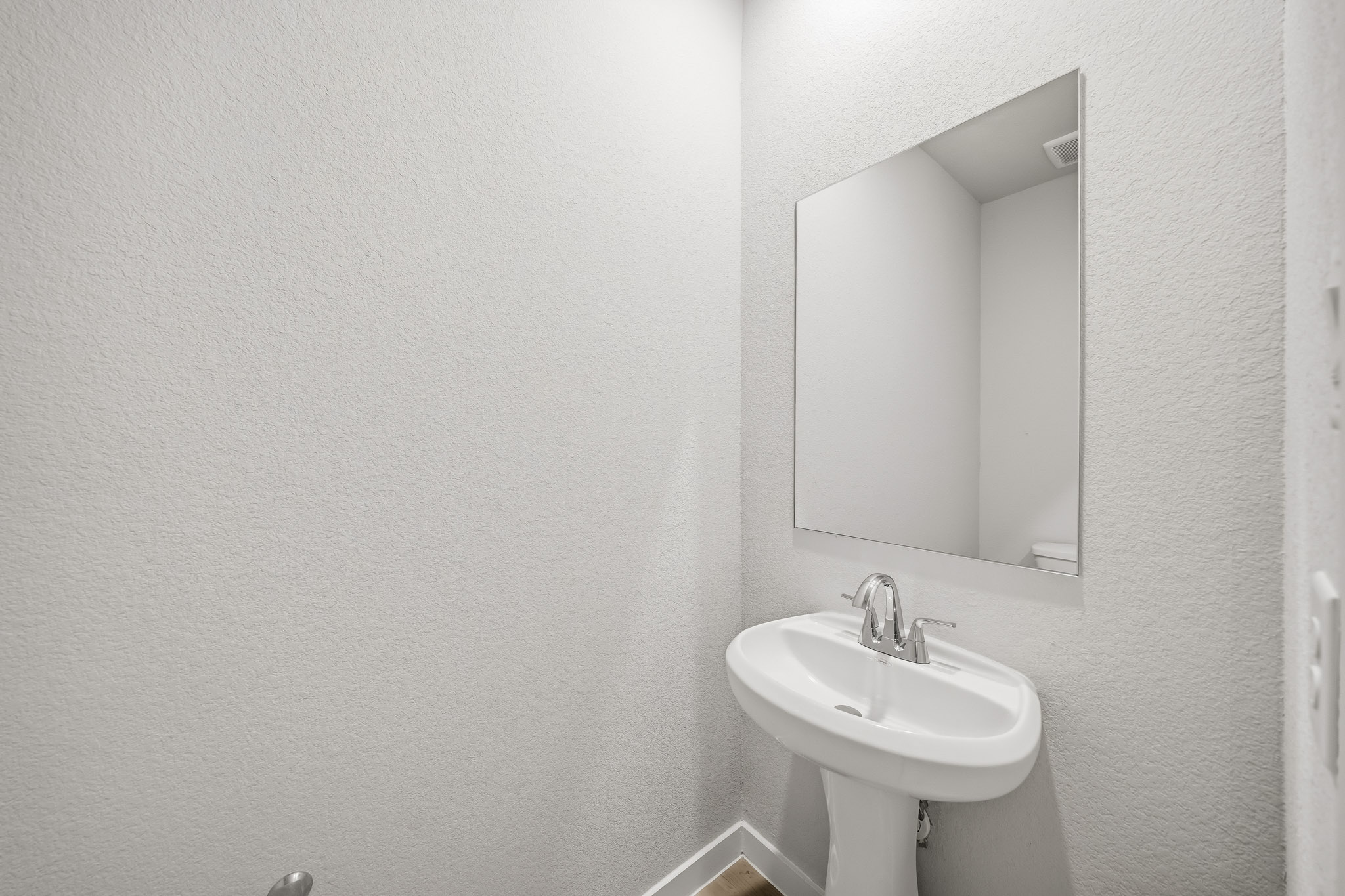 A bathroom with a mirror and sink.