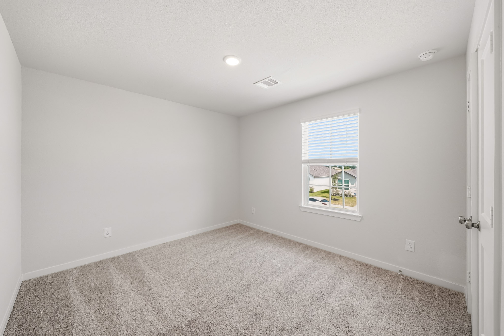 A room with a window and carpet.
