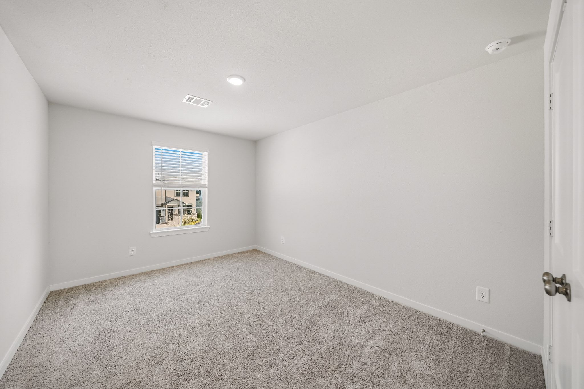 A room with a carpet and a window.