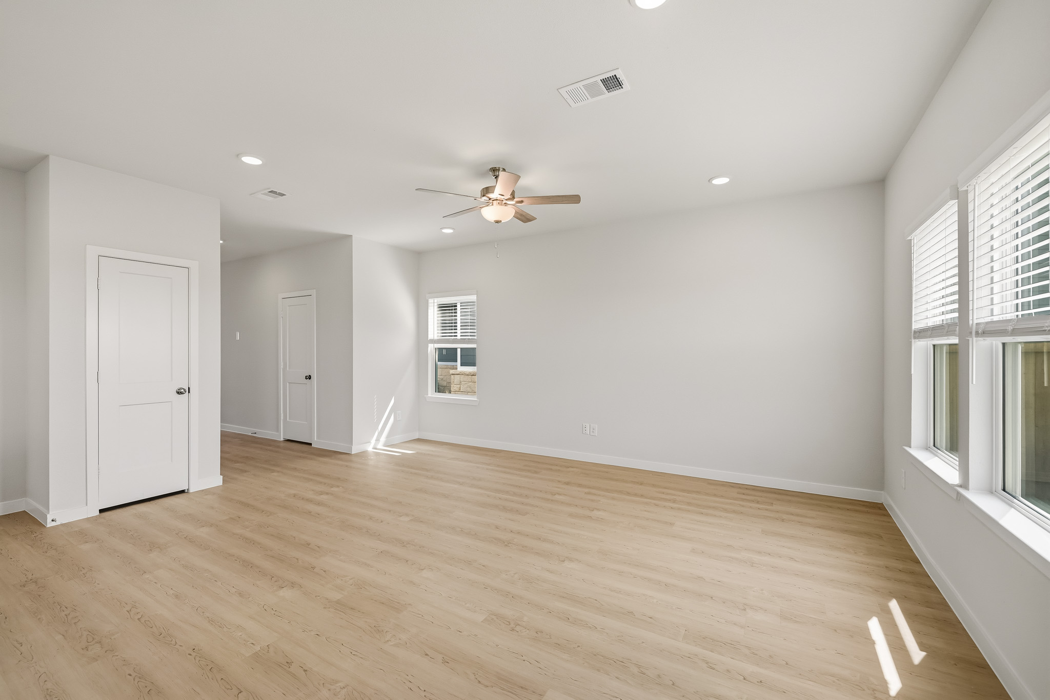 A room with a wood floor and a ceiling fan.