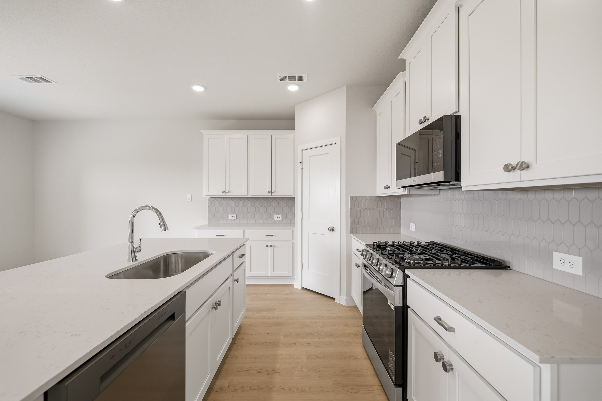 A kitchen with white cabinets.