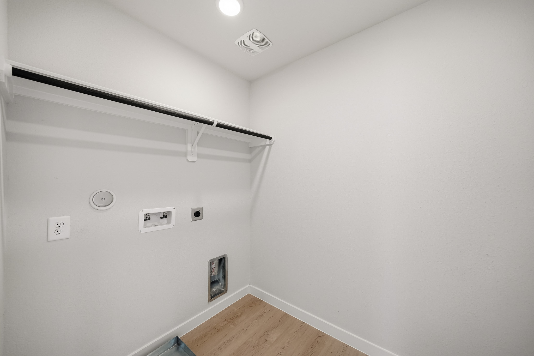 A white wall with a wood floor.
