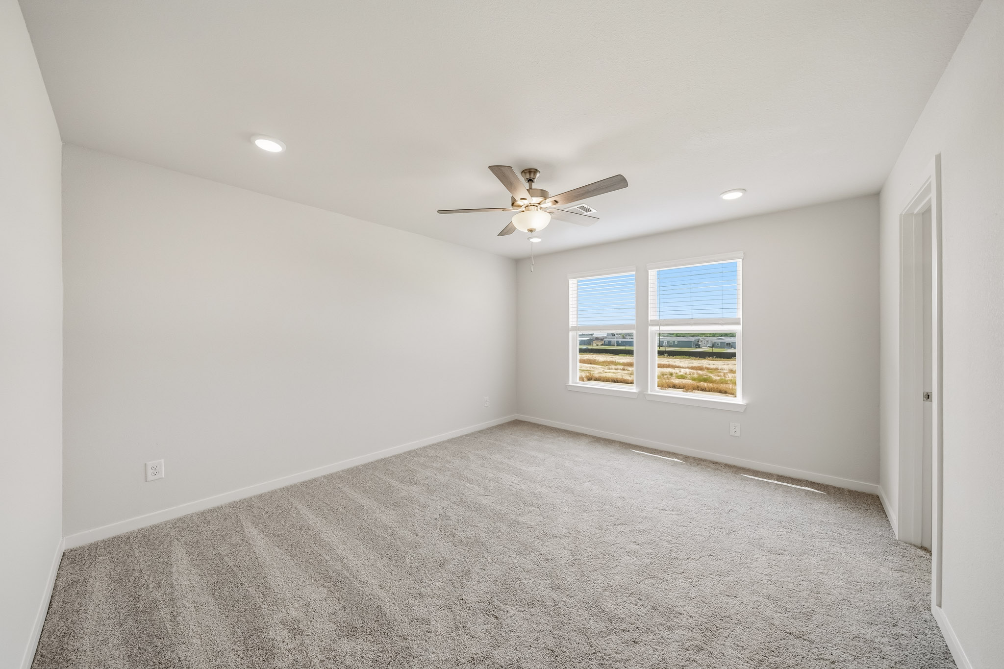A room with a ceiling fan and a window.