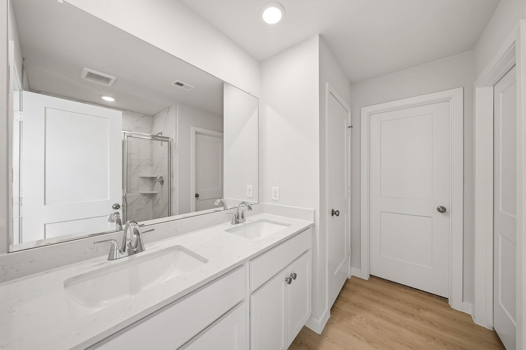 A bathroom with white cabinets.