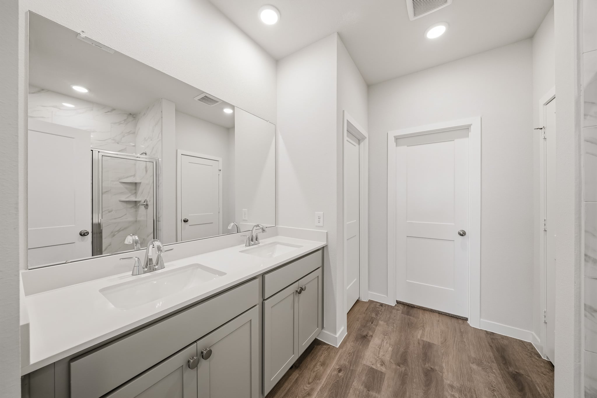 A bathroom with white cabinets.