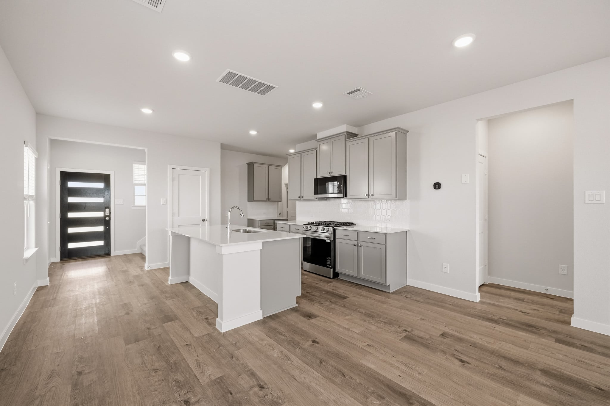 A kitchen with white cabinets.