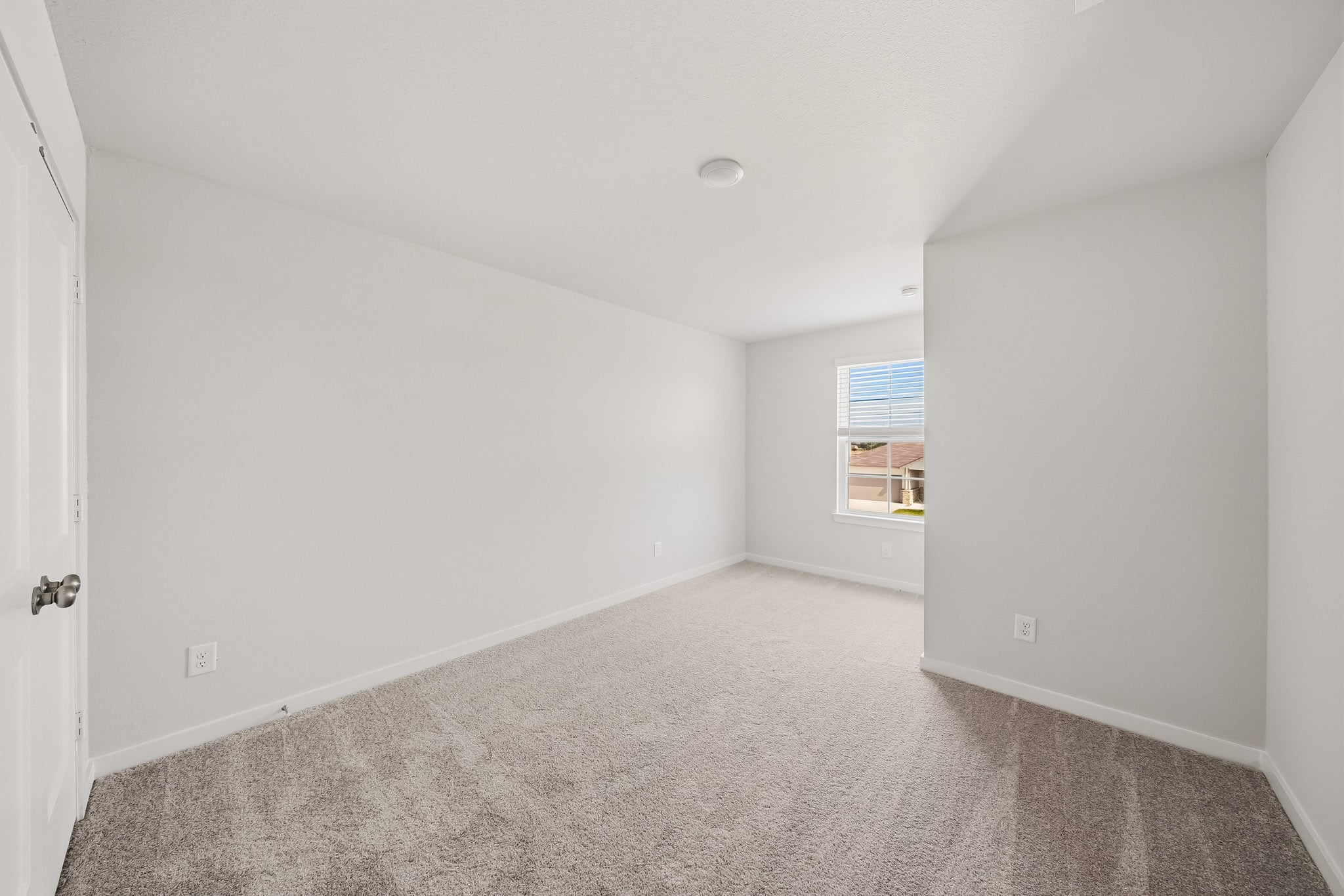 A room with a carpet and a window.