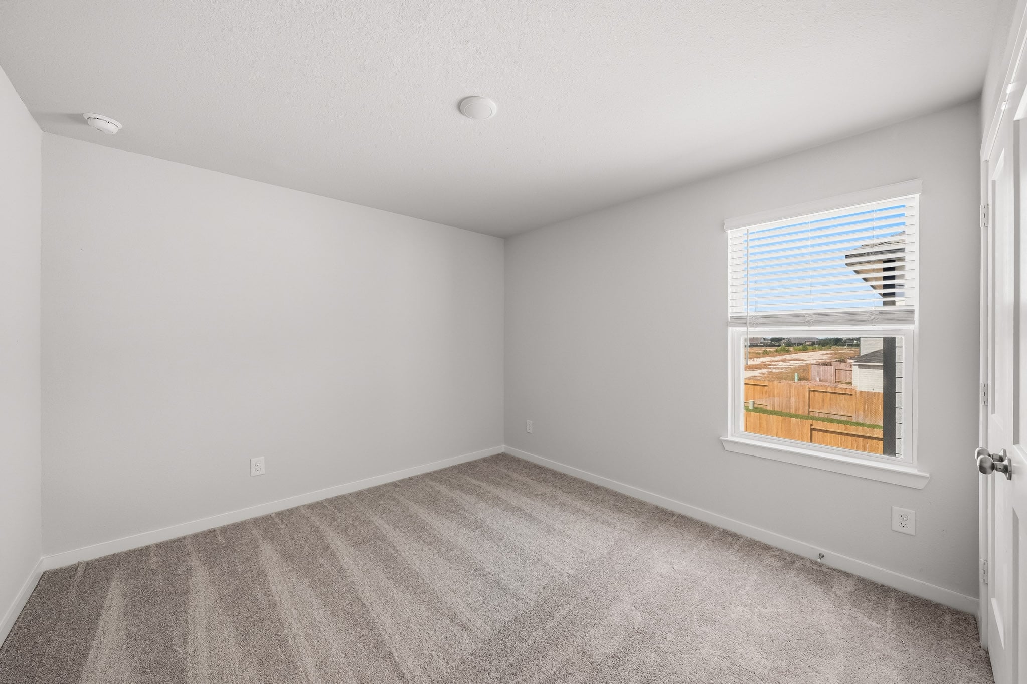 A room with a window and a carpet.