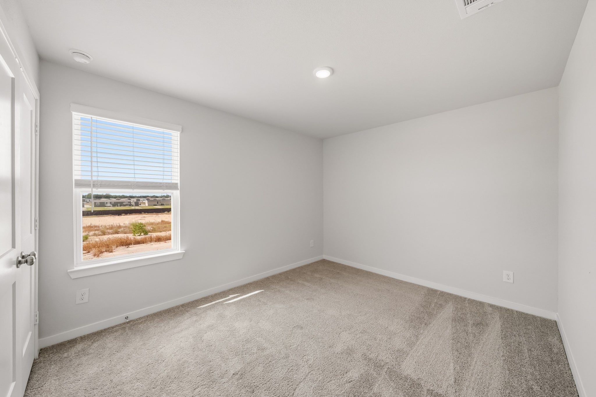 A room with a window and carpet.