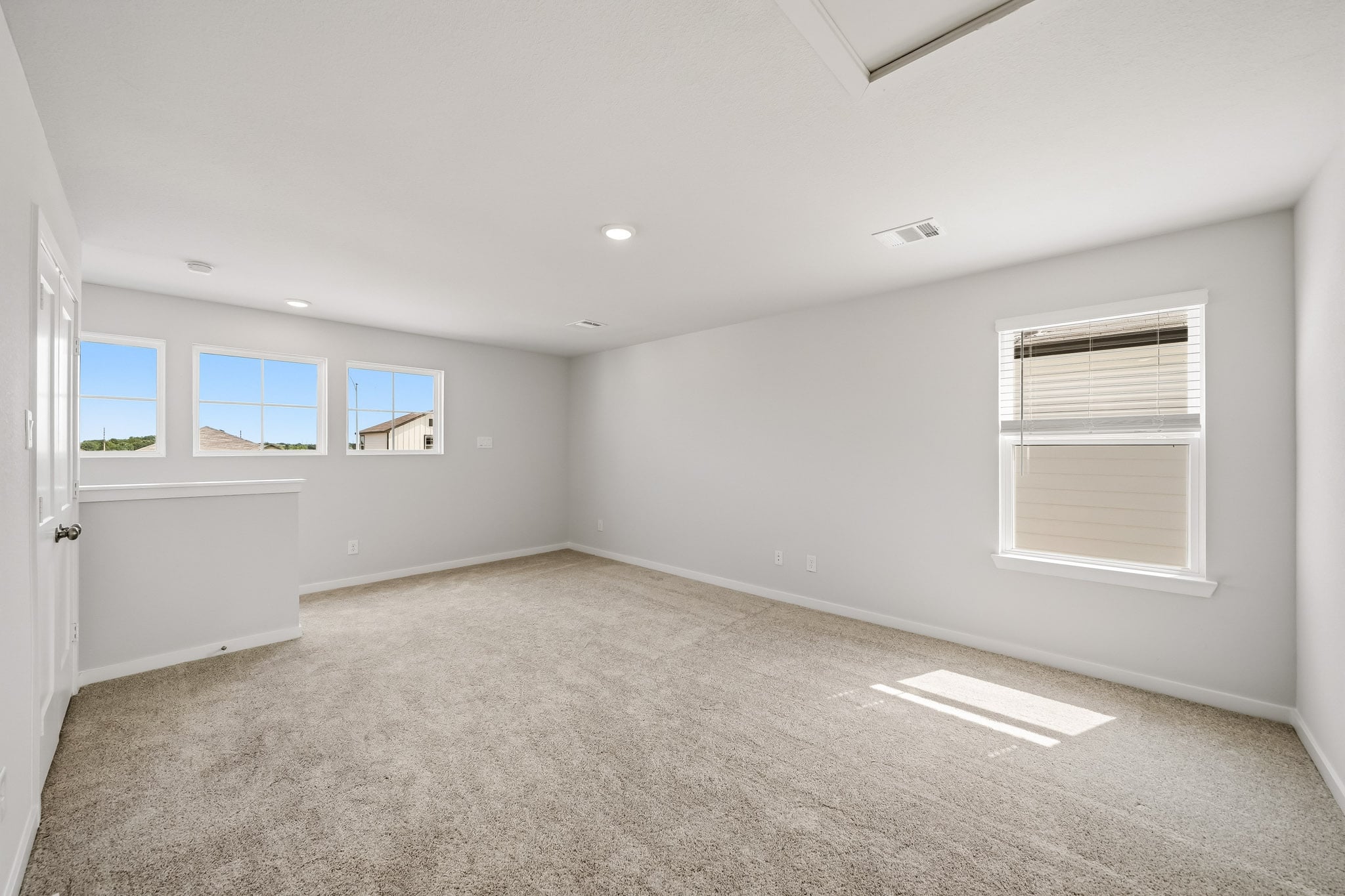 A room with a carpet and windows.