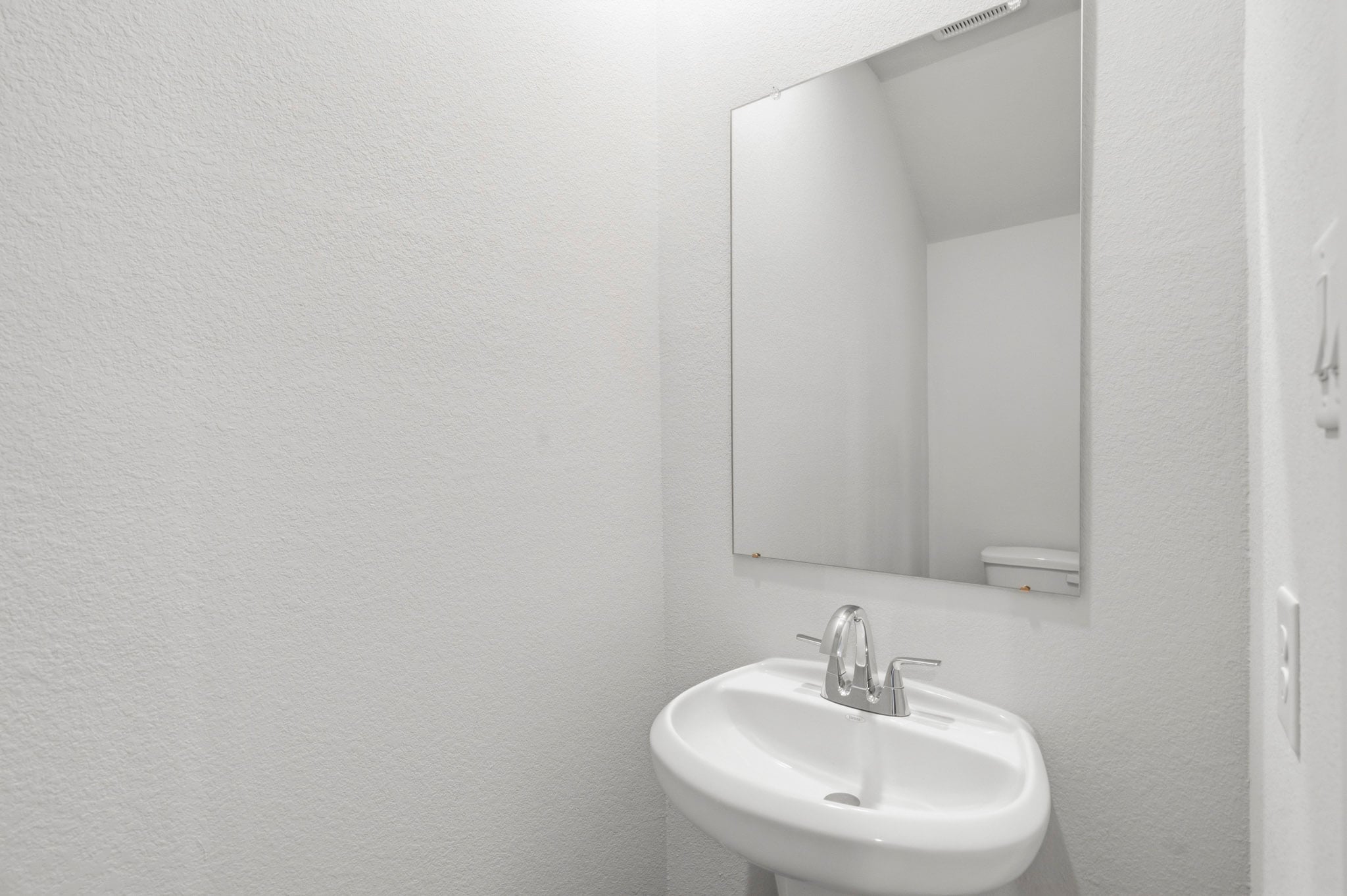 A bathroom with a large mirror.