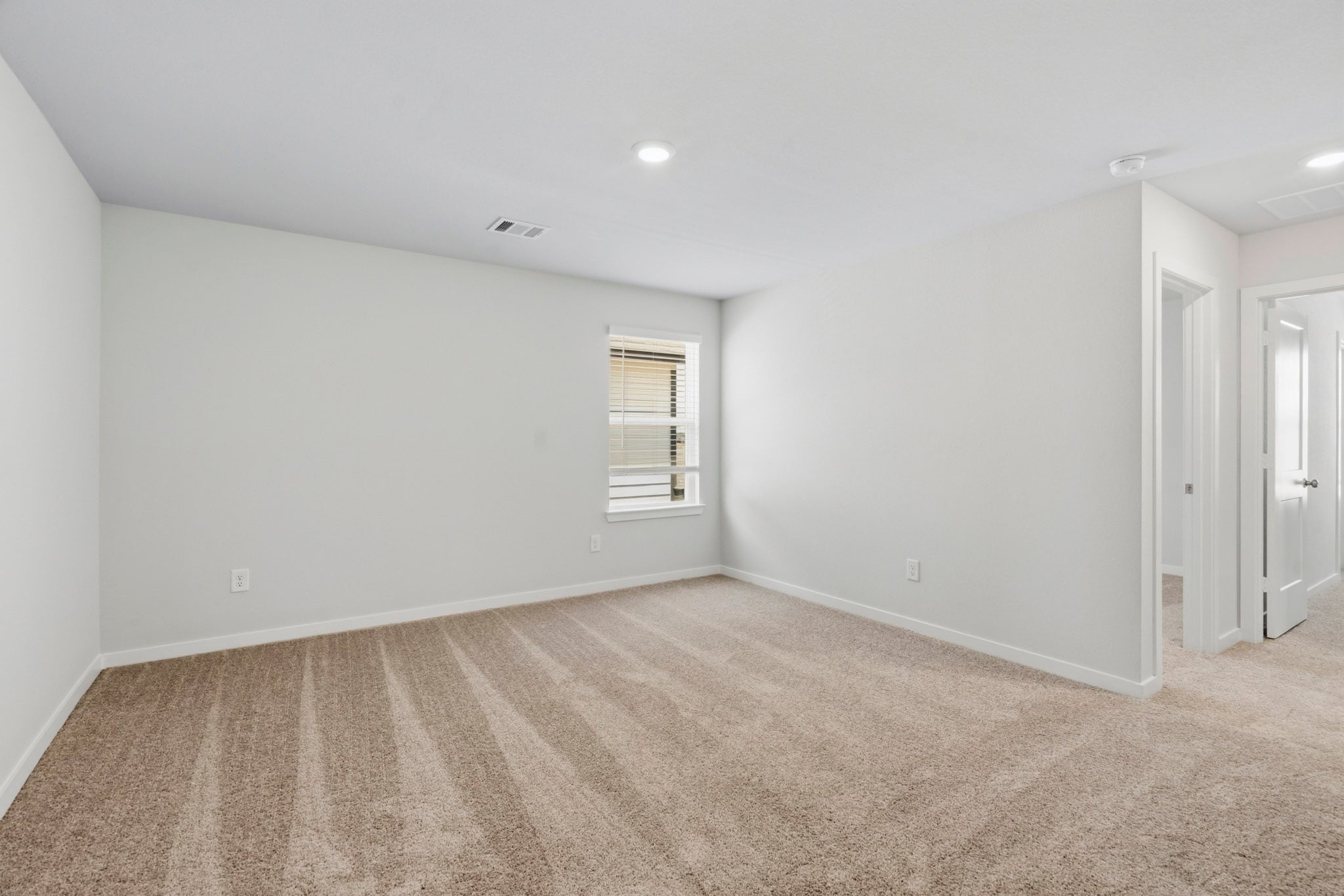 A room with a carpet and a door.