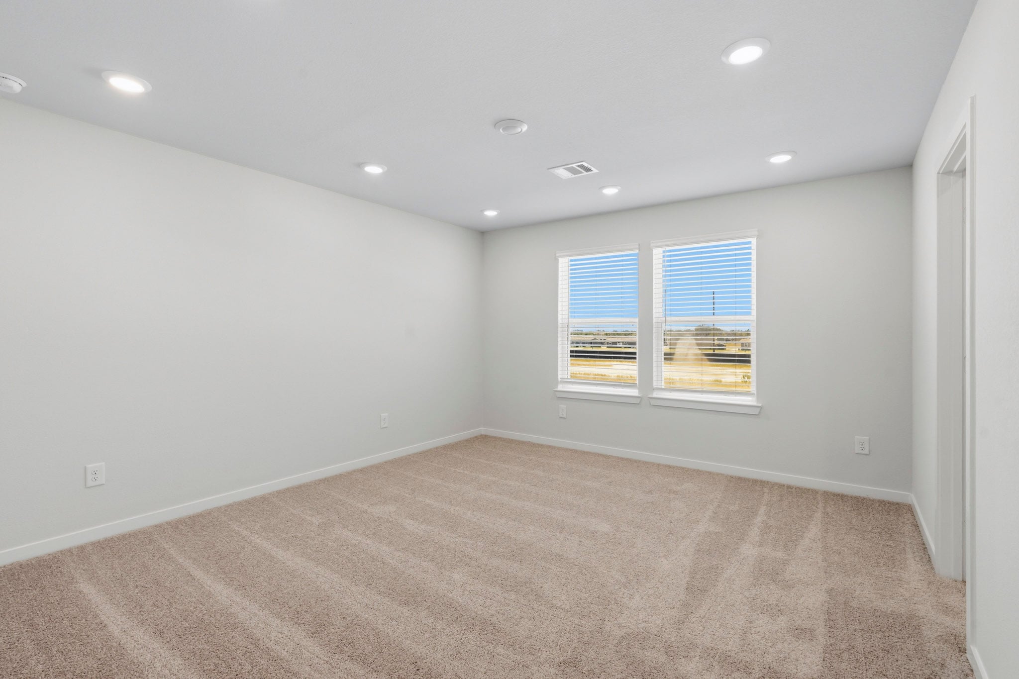 A room with a carpet and windows.