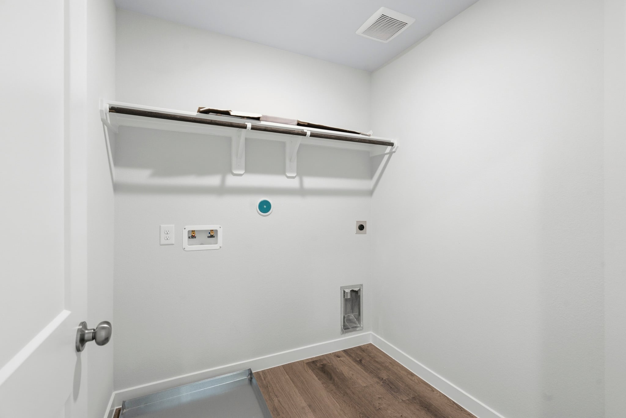 A white wall with a metal bar.