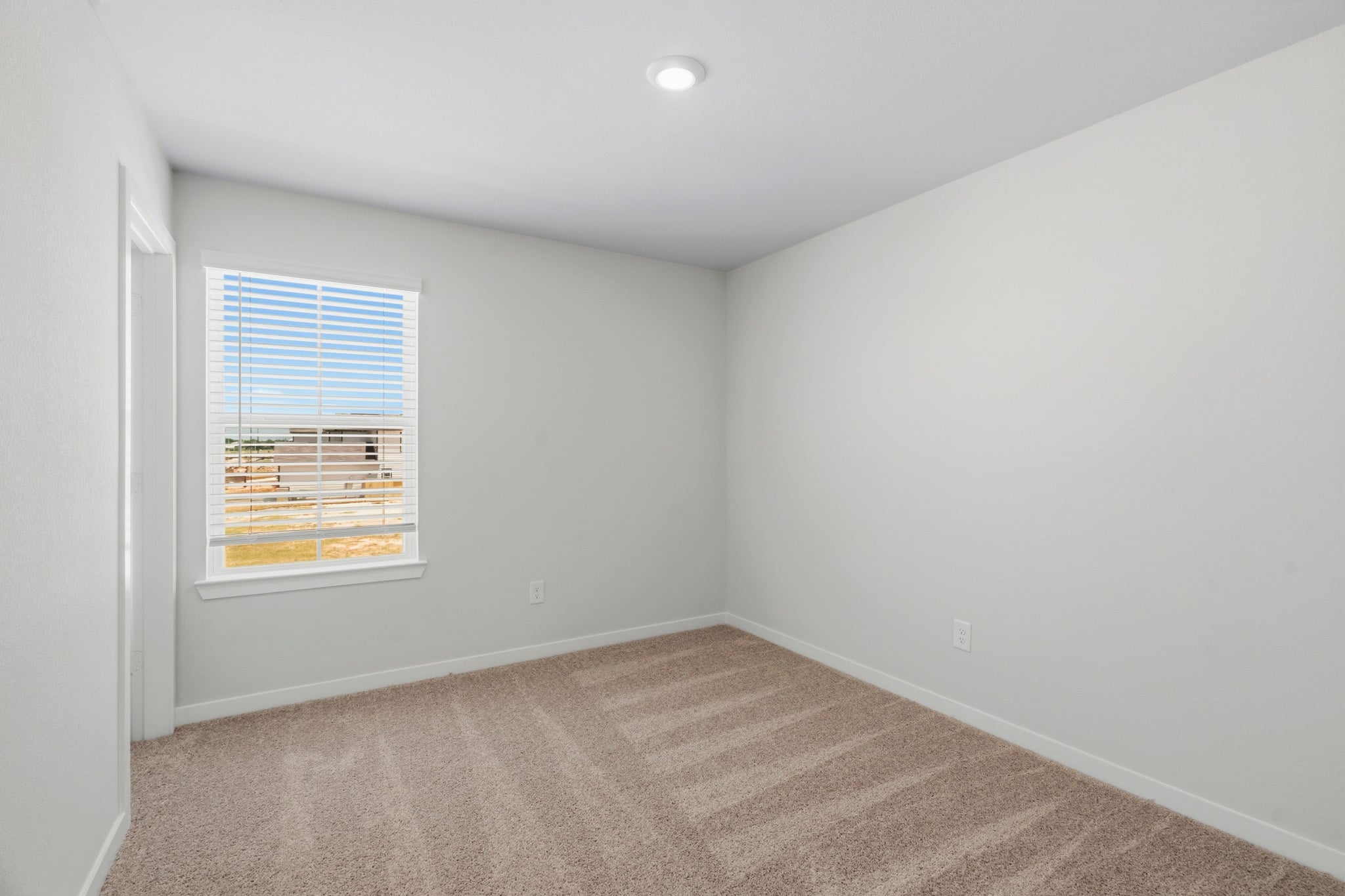 A room with a window and a carpet.