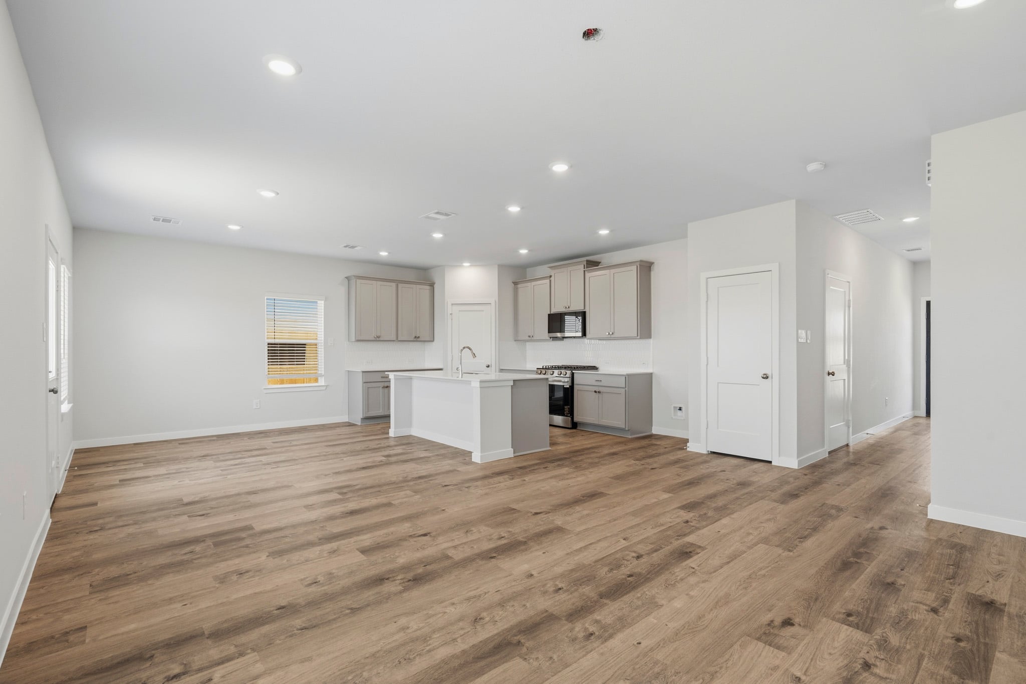 A large empty room with white cabinets.