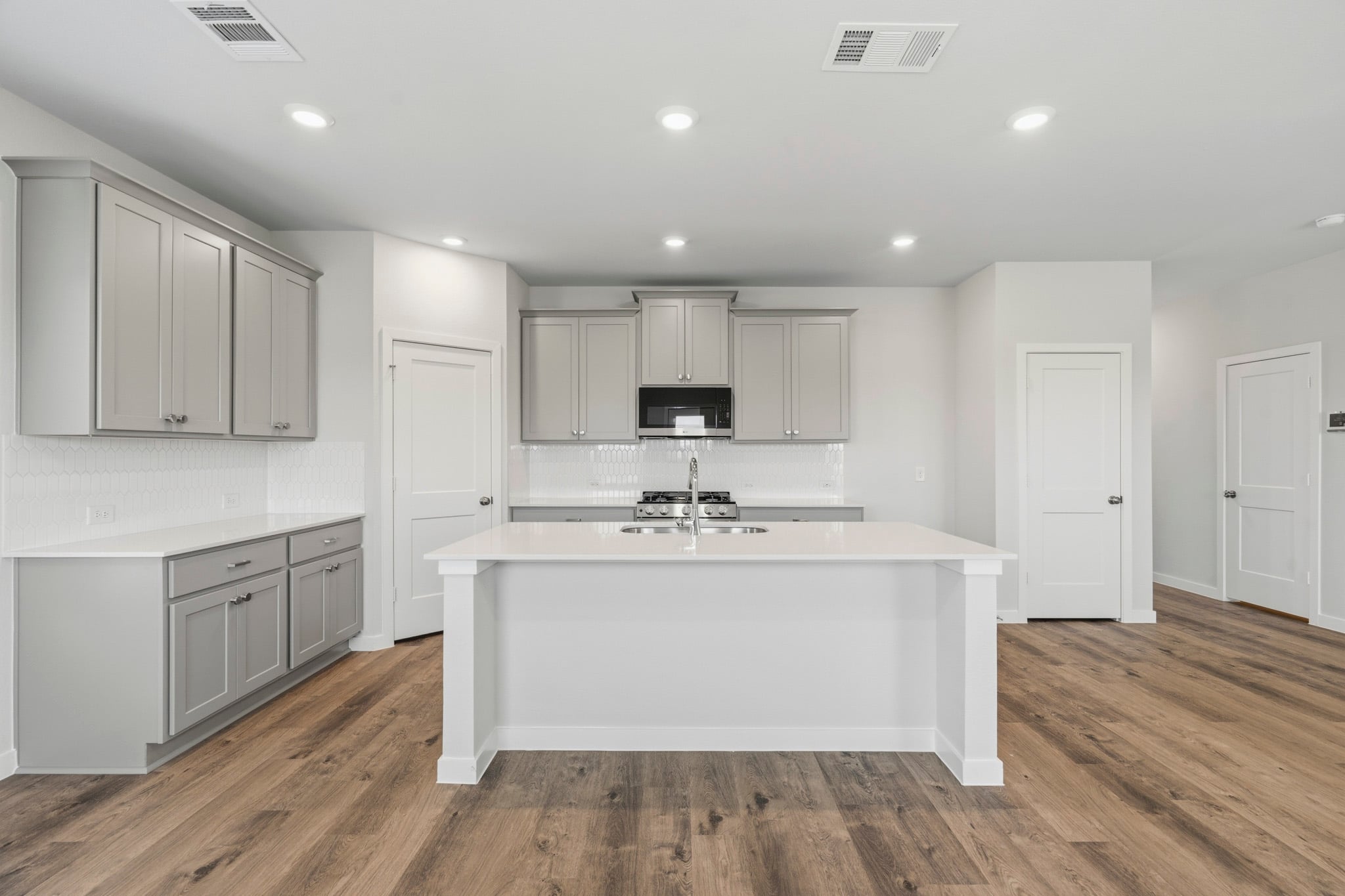 A kitchen with white cabinets.