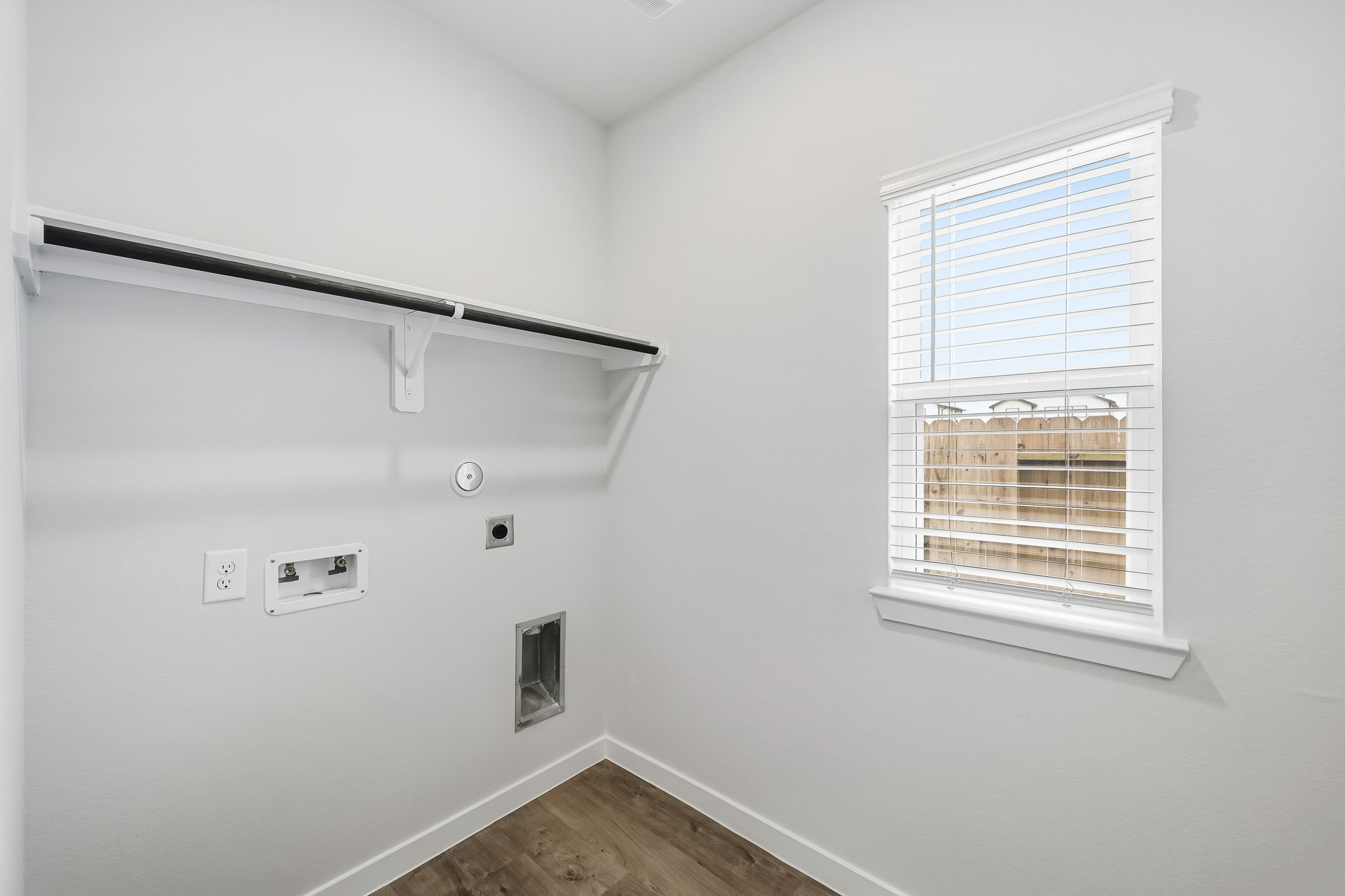 A room with a window and a wood floor.