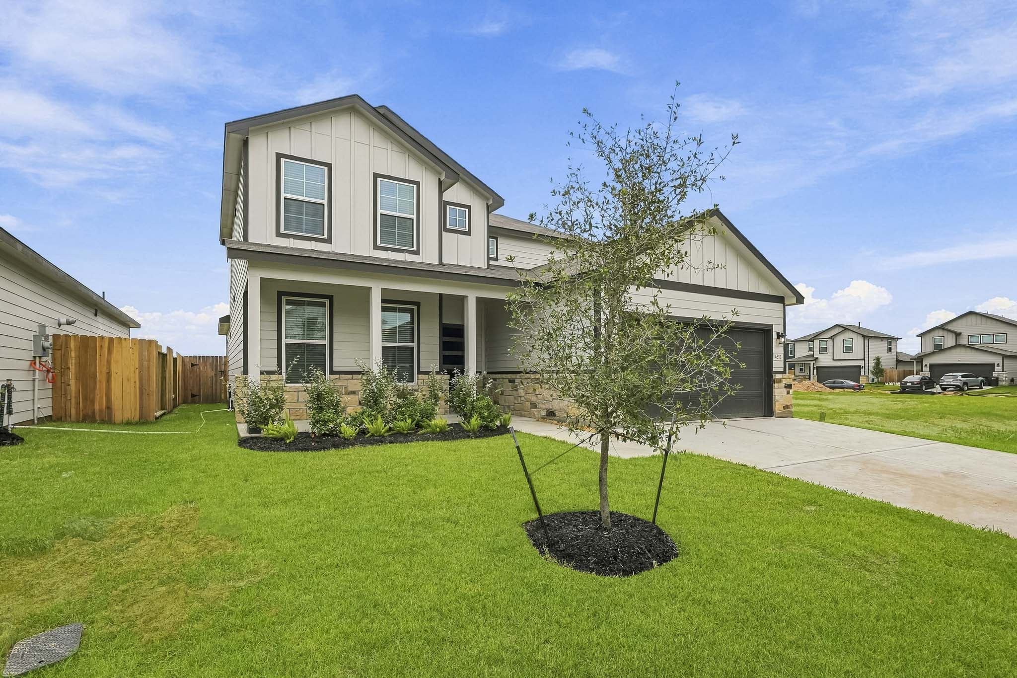A house with a tree in the front yard.