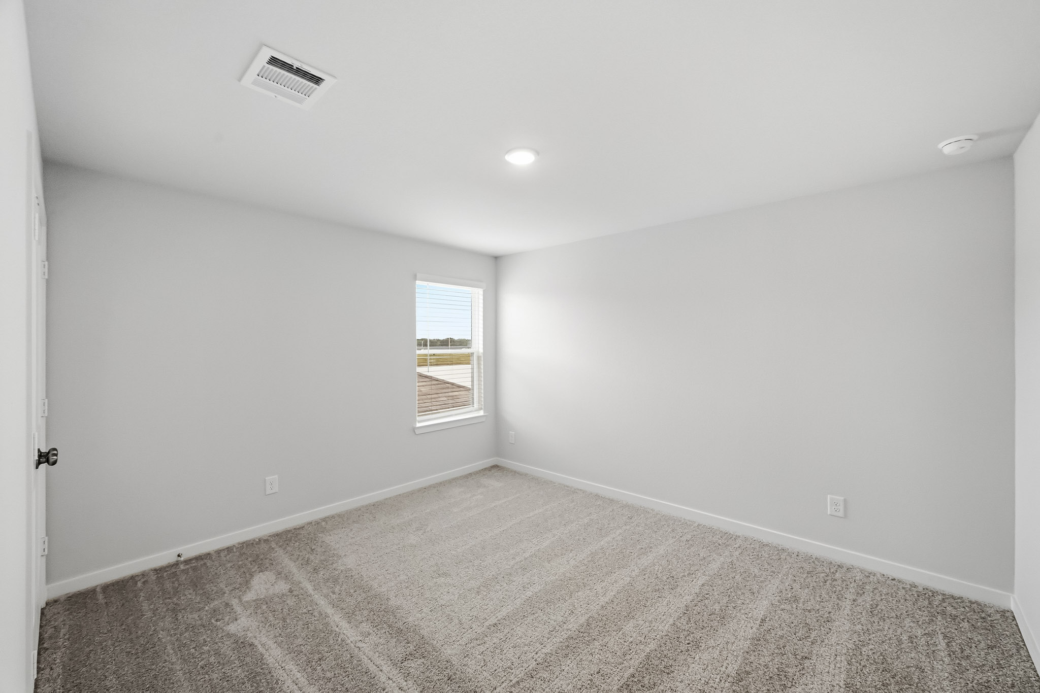 A room with a carpet and a window.