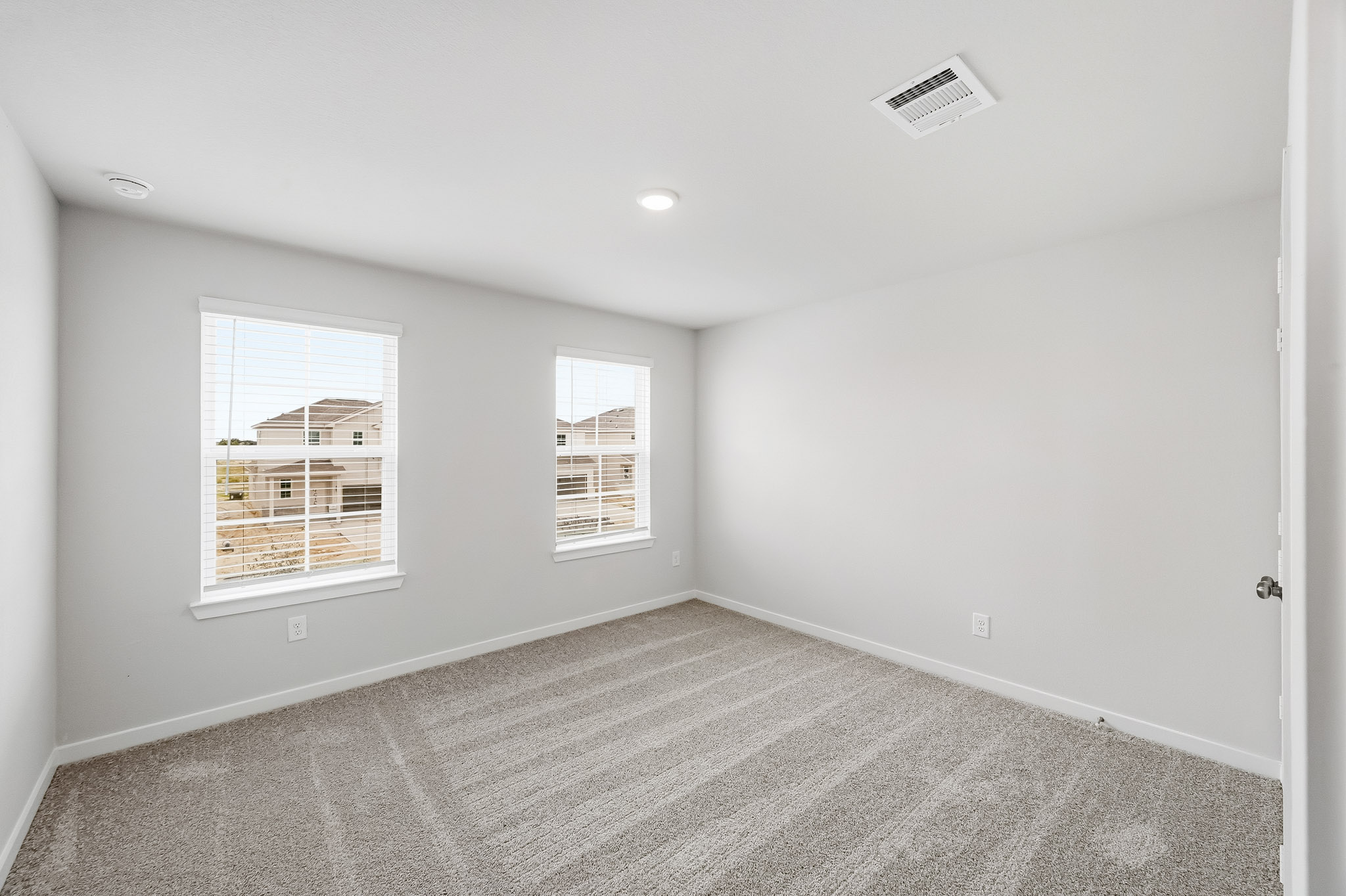 A room with a window and a carpet.