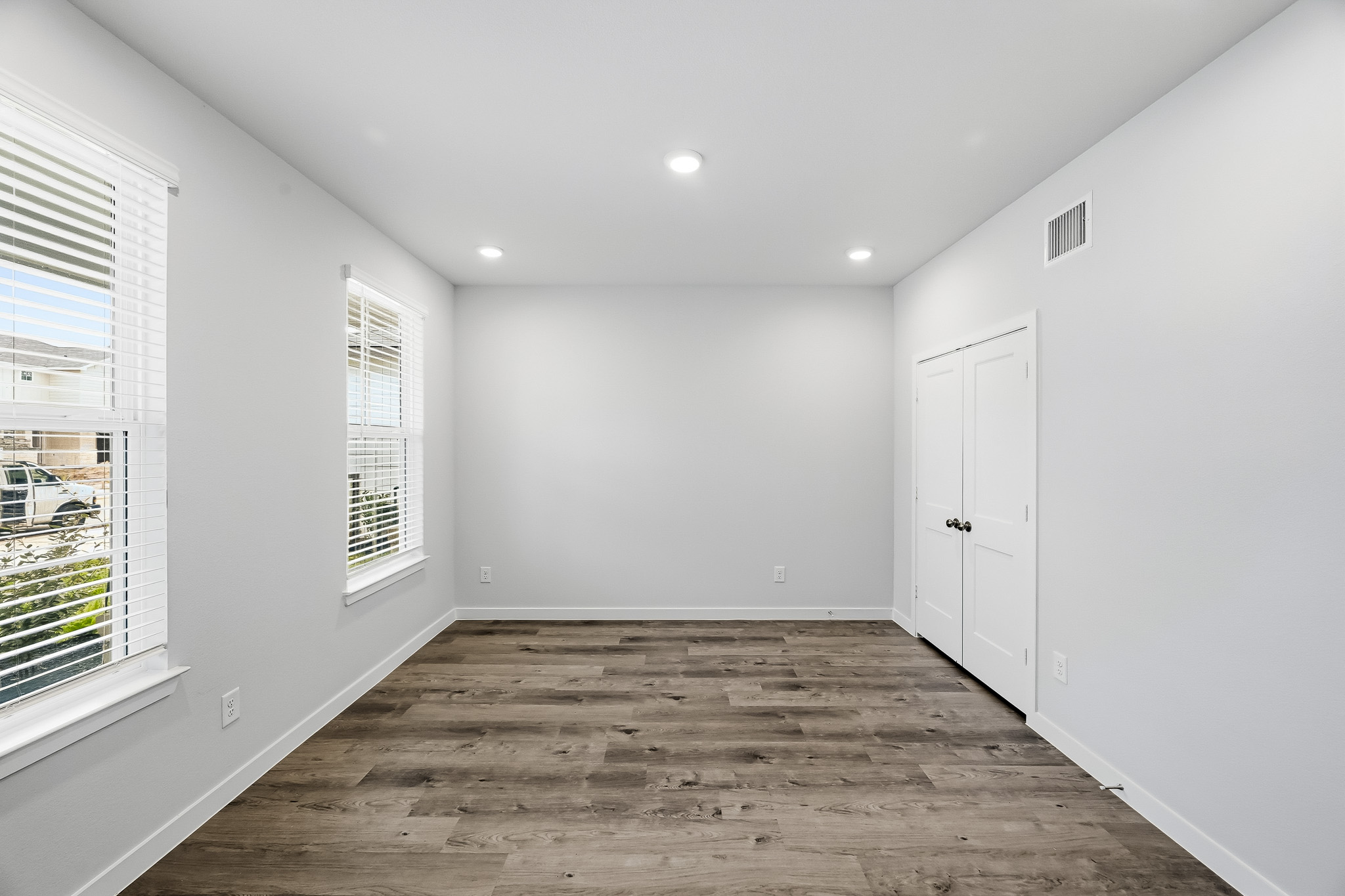 A room with white walls and a wood floor.