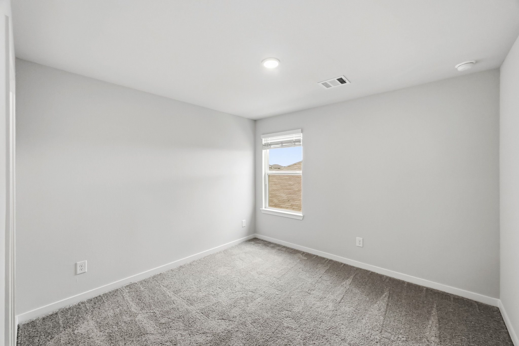 A room with a window and carpet.
