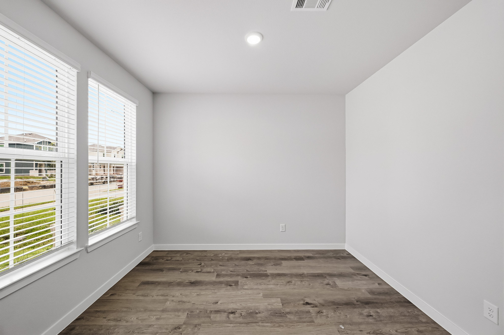 A room with windows and a wood floor.