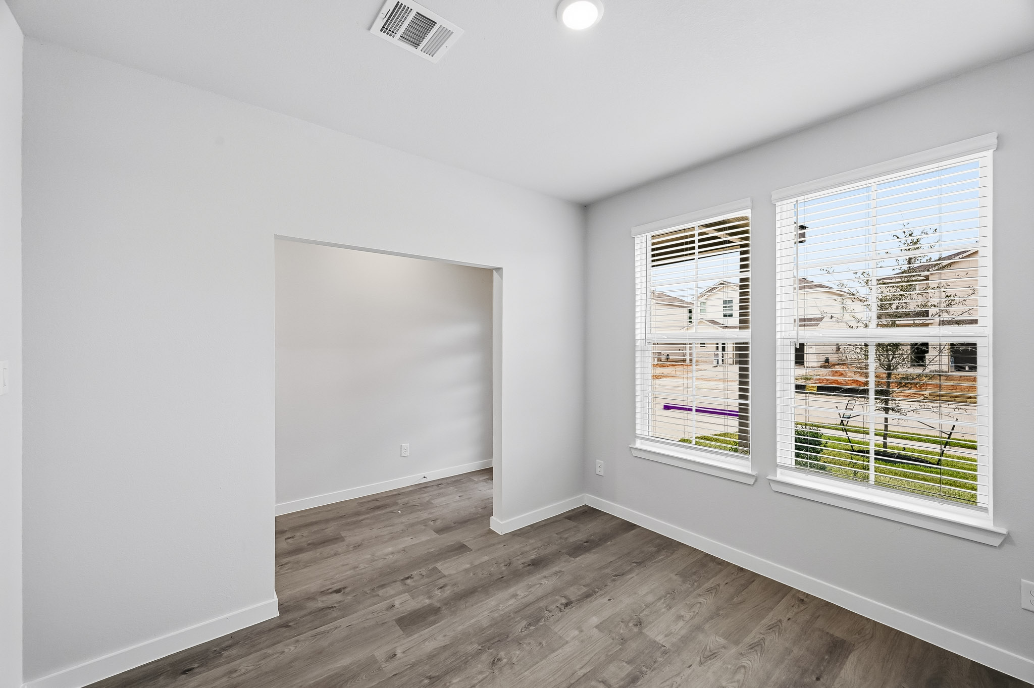 A room with a window and a wood floor.
