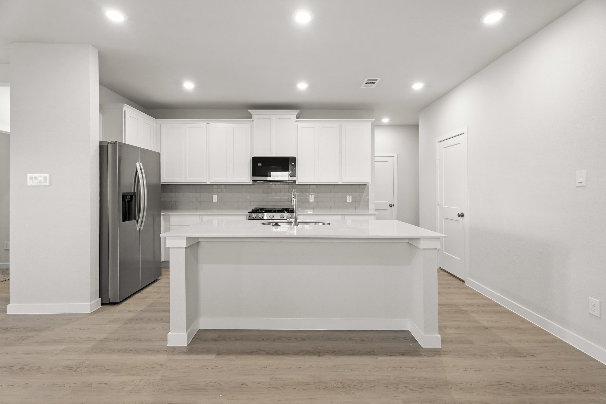 A kitchen with white cabinets.
