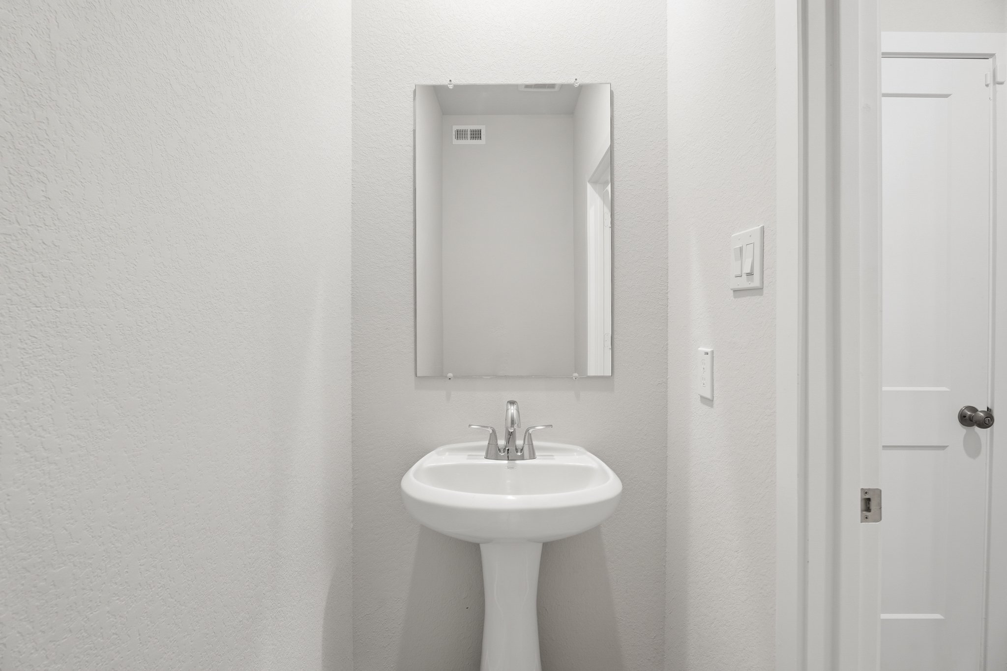 A bathroom with a sink and mirror.