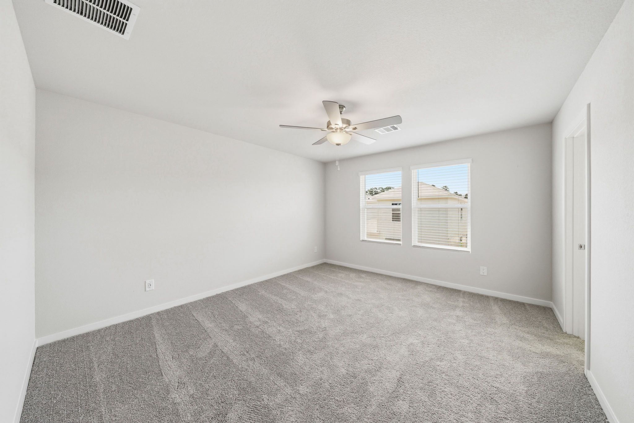 A room with a ceiling fan and a window.