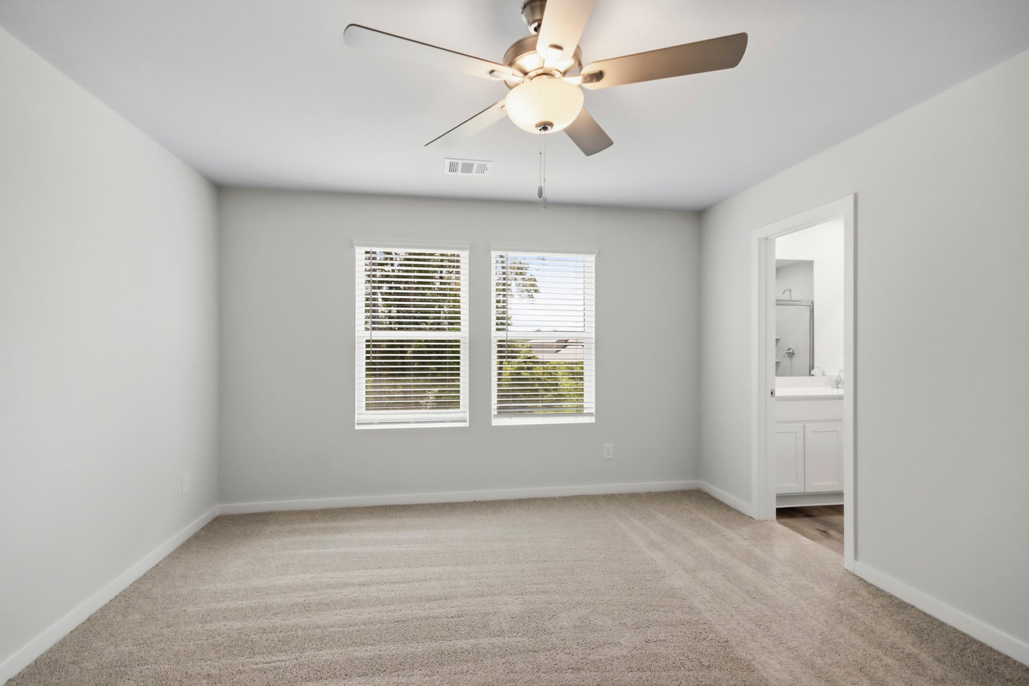 A room with a ceiling fan and a window.