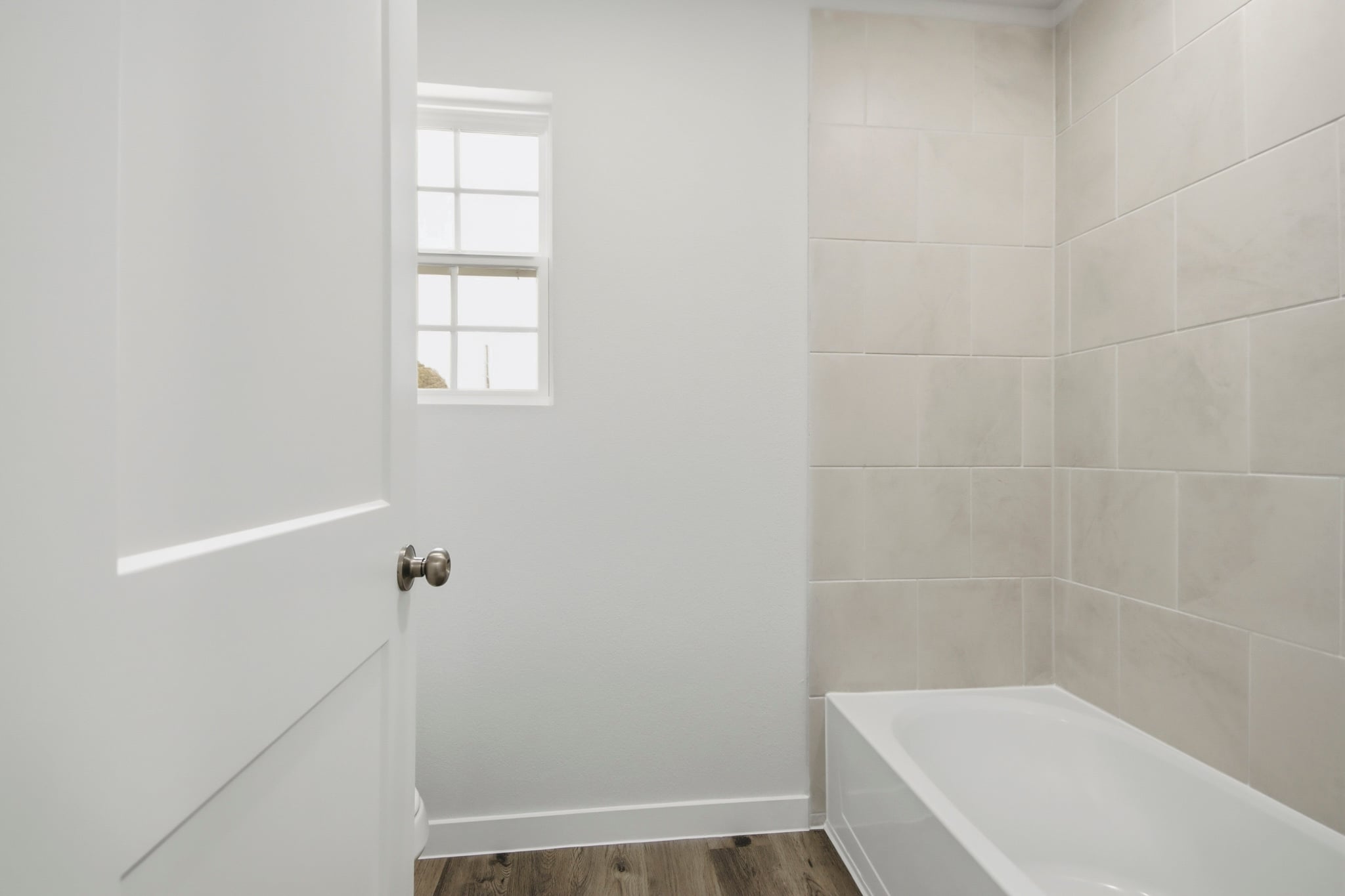 A bathroom with a tub and a window.