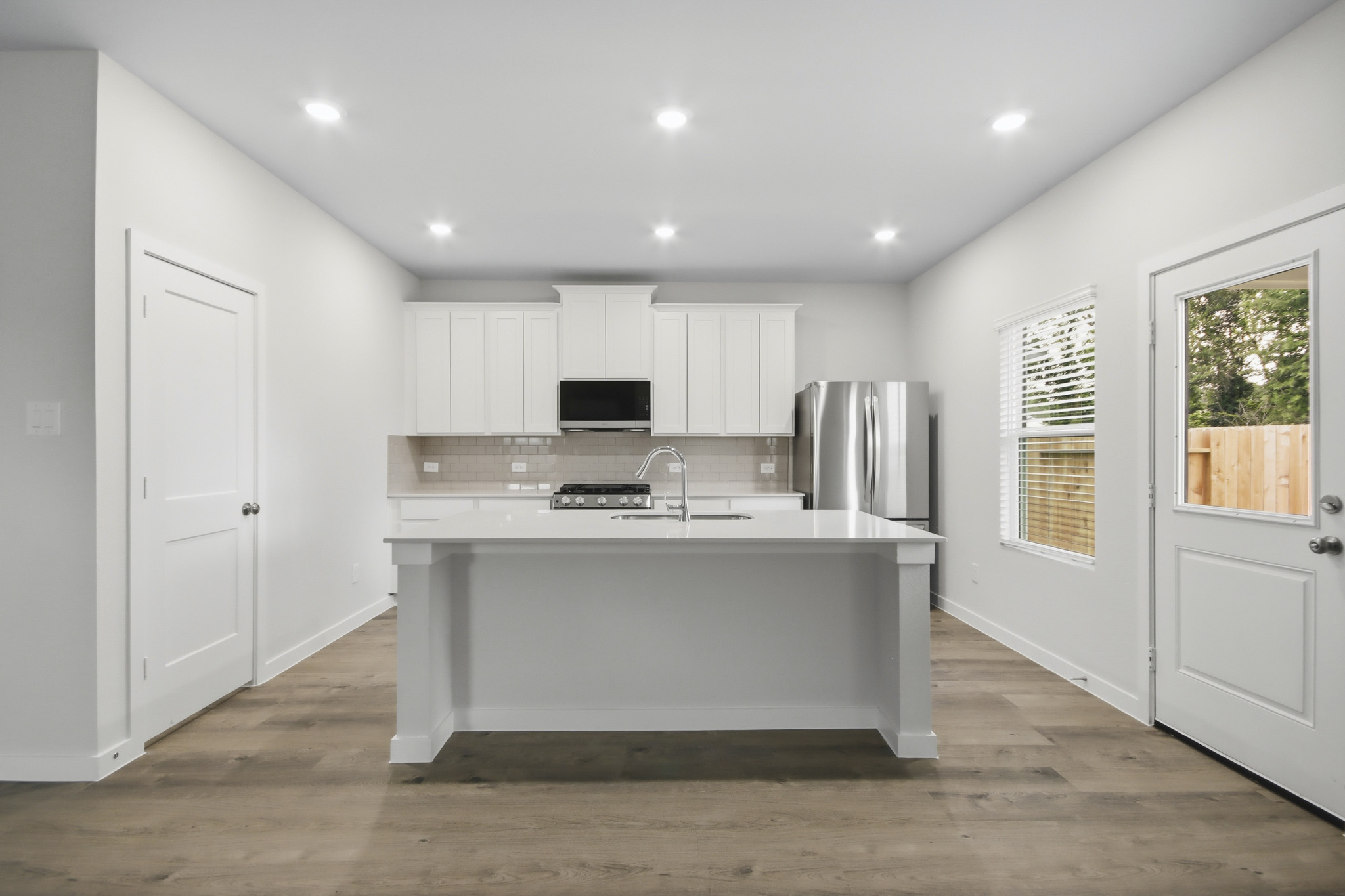 A kitchen with white cabinets.