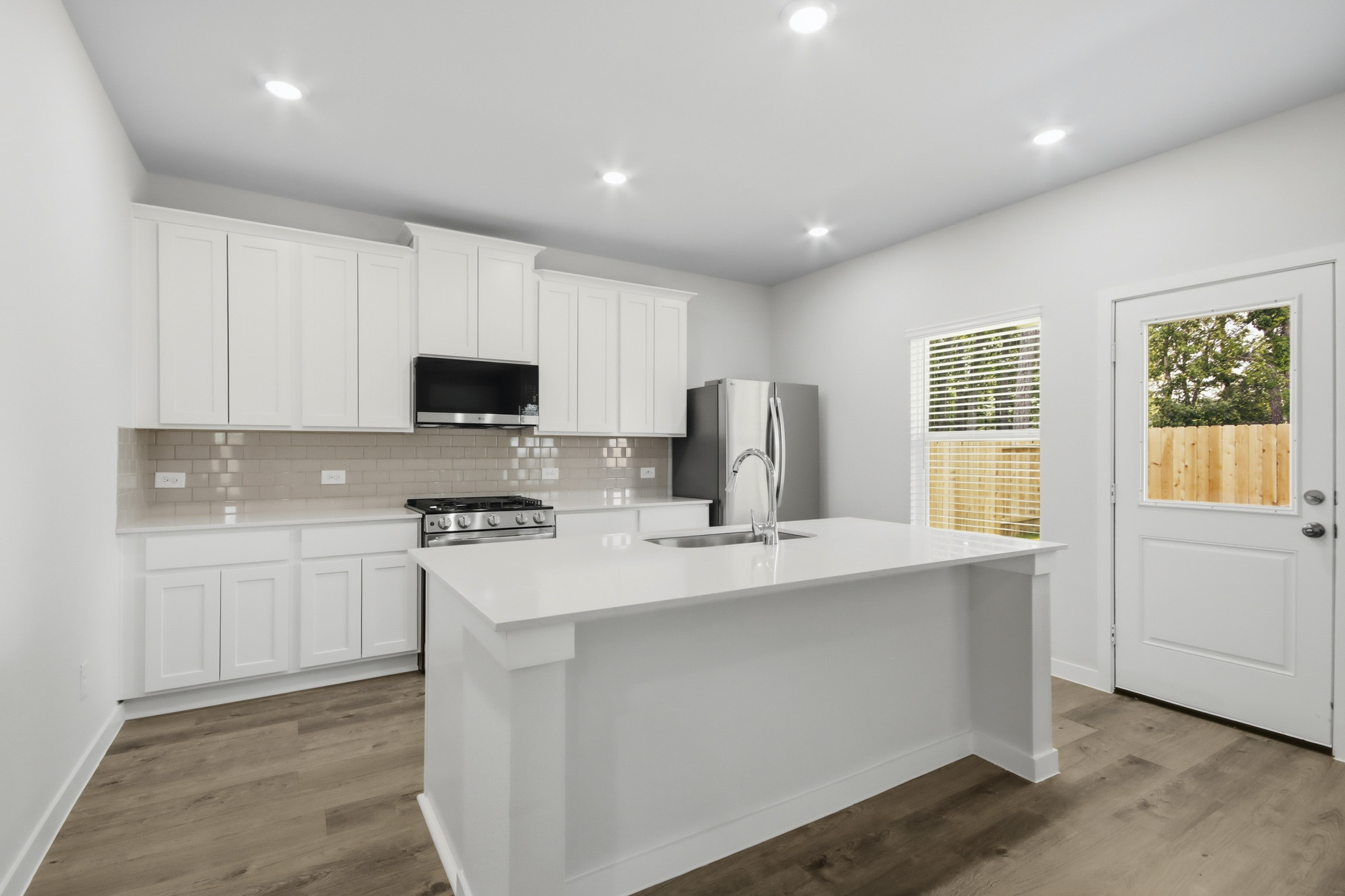 A kitchen with white cabinets.
