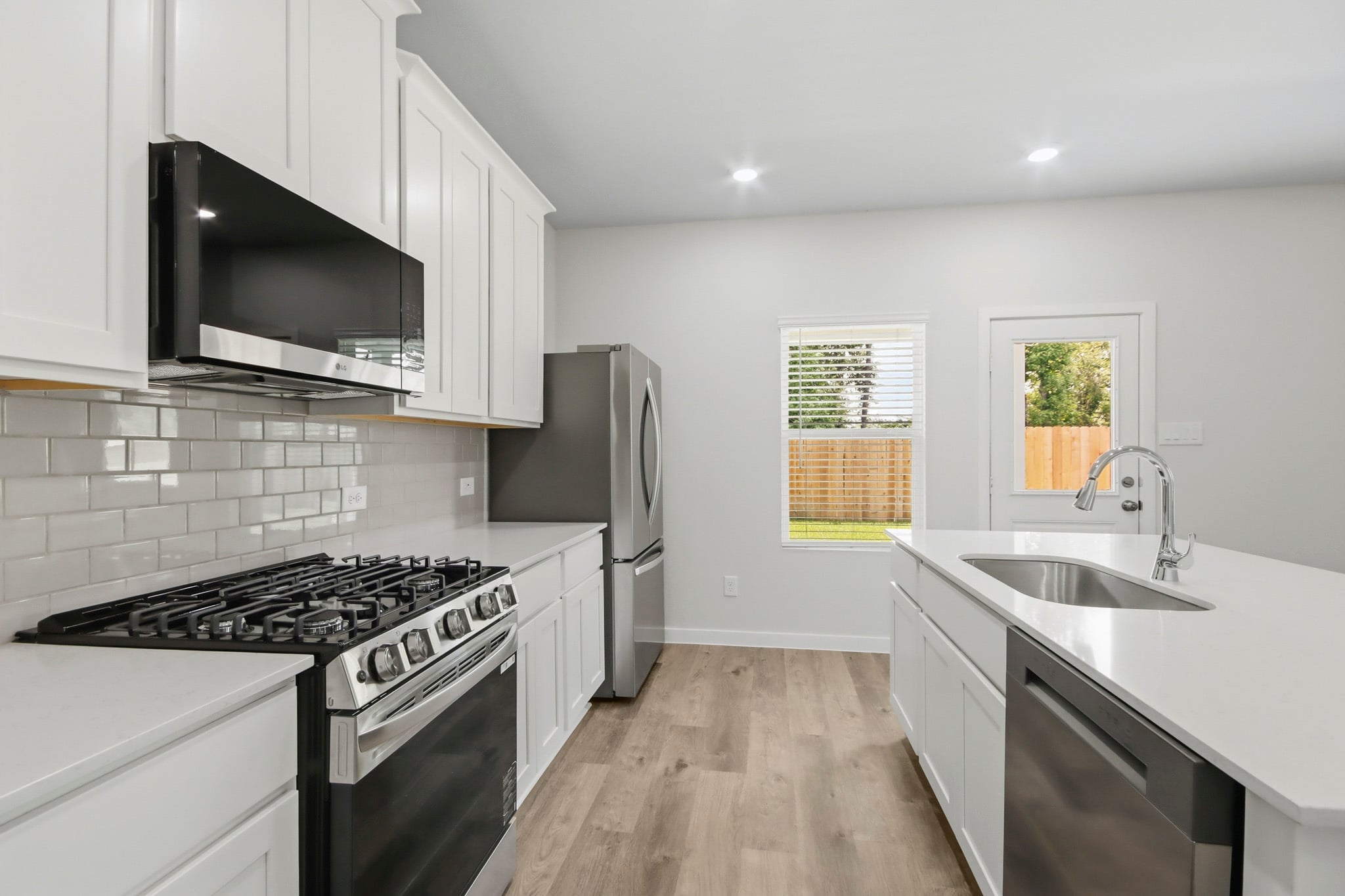 A kitchen with white cabinets.