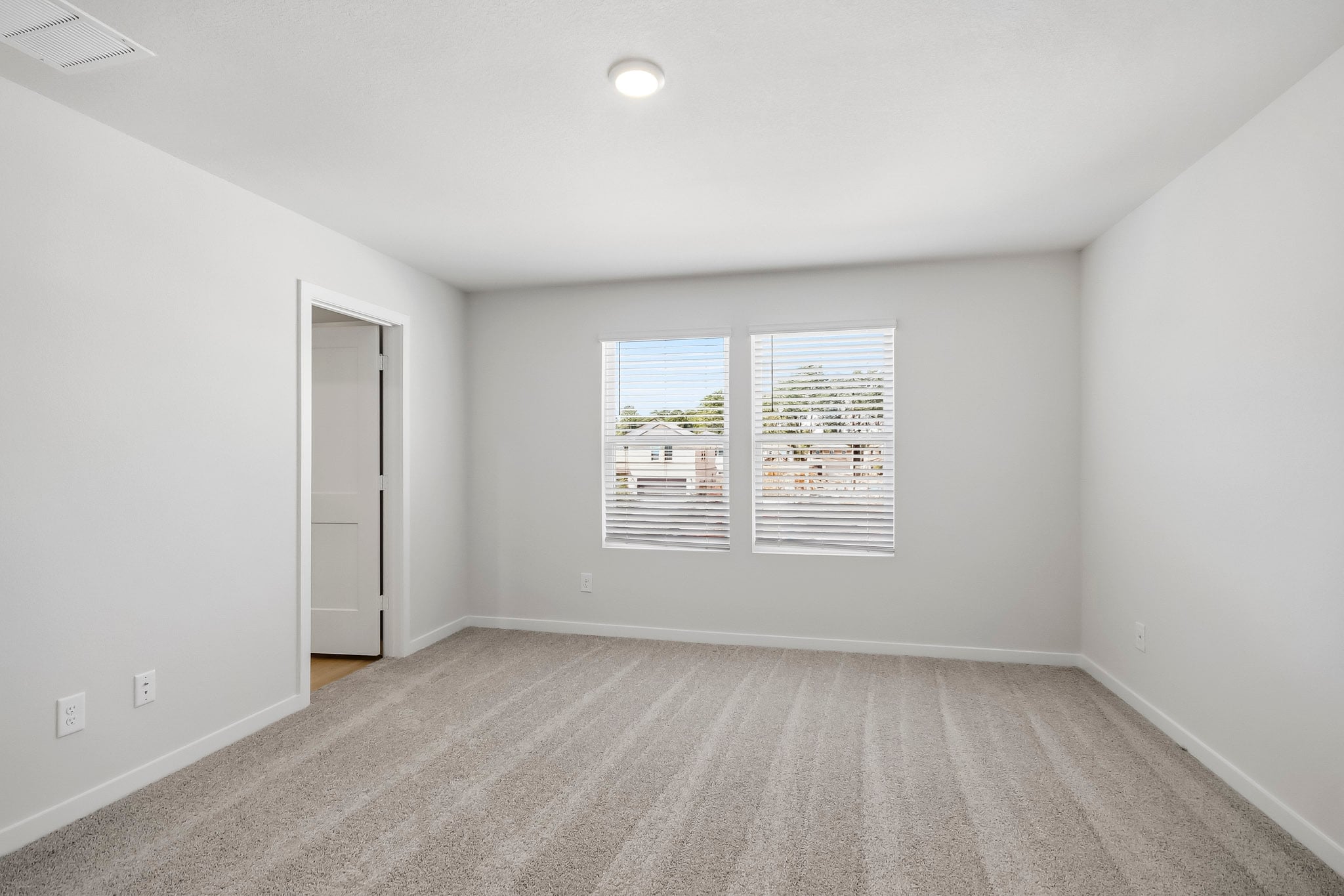 A room with a white wall and a door with a picture on it.