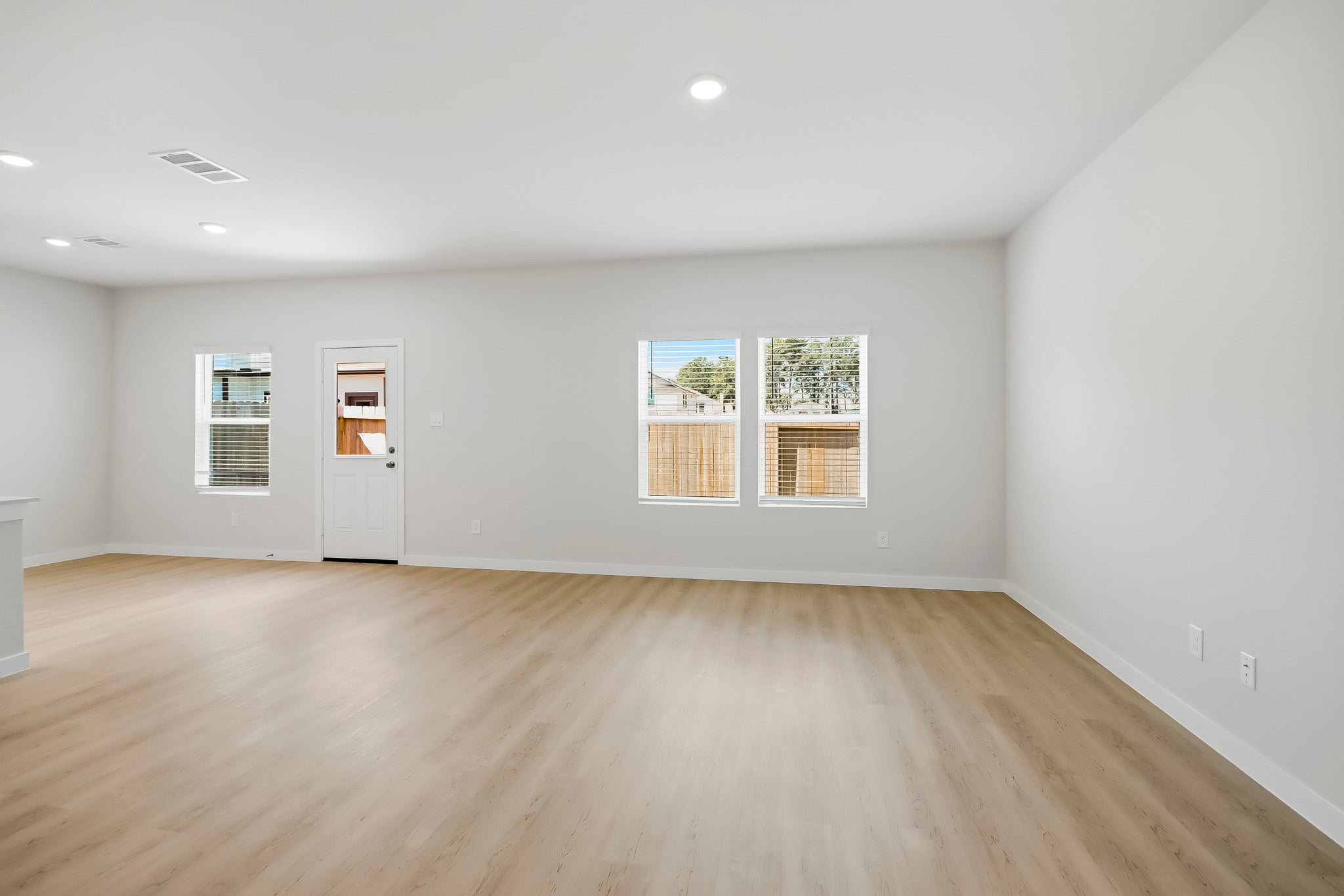 A room with a wood floor and a wood floor with a white door.