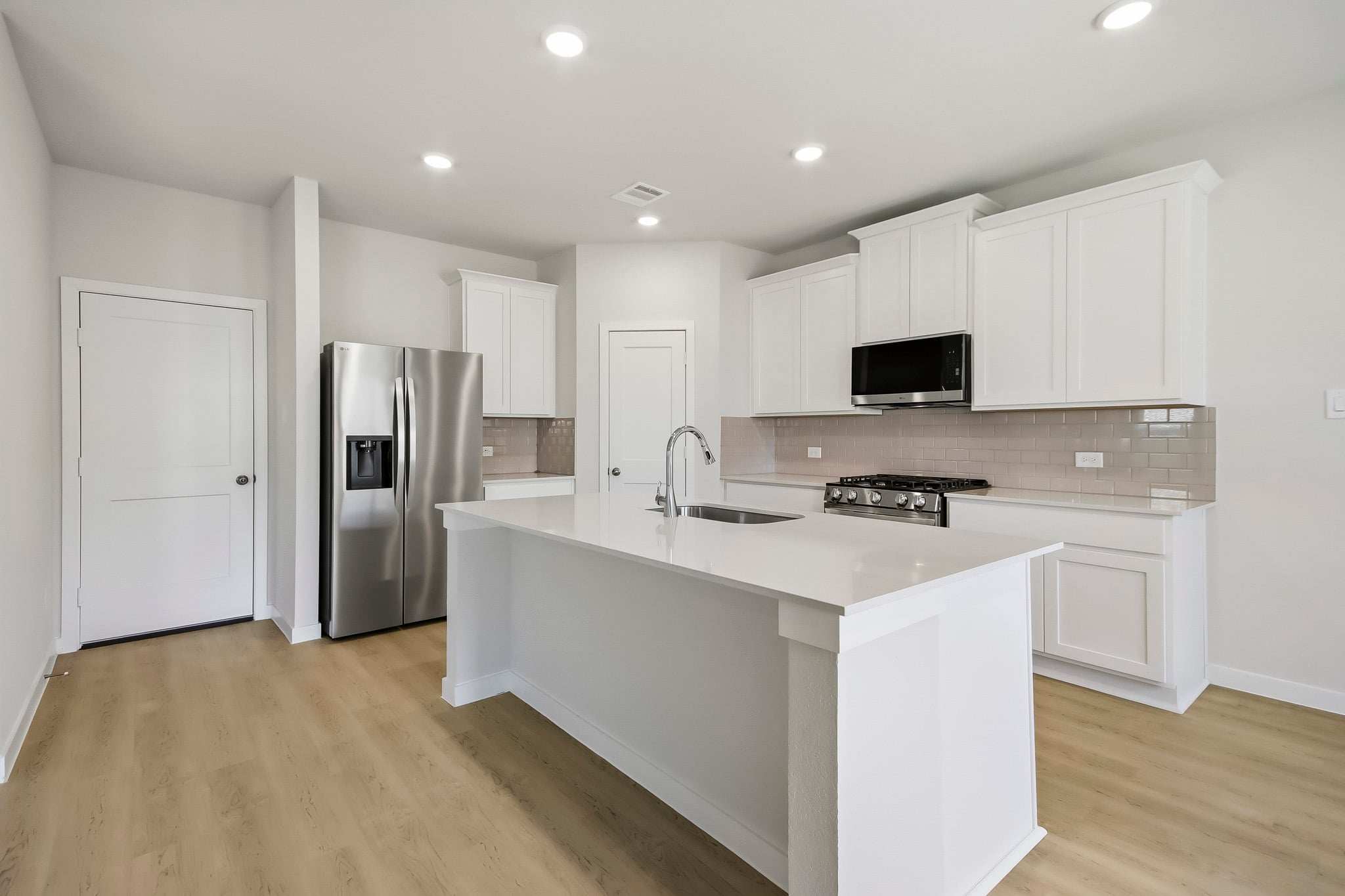 A kitchen with white cabinets.