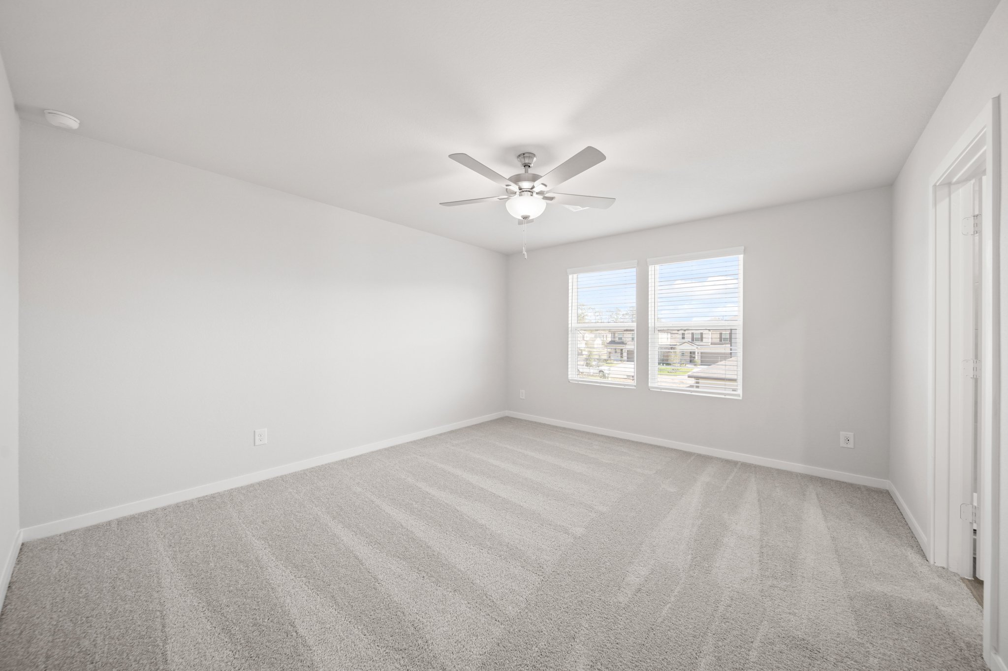 A room with a ceiling fan and a window.
