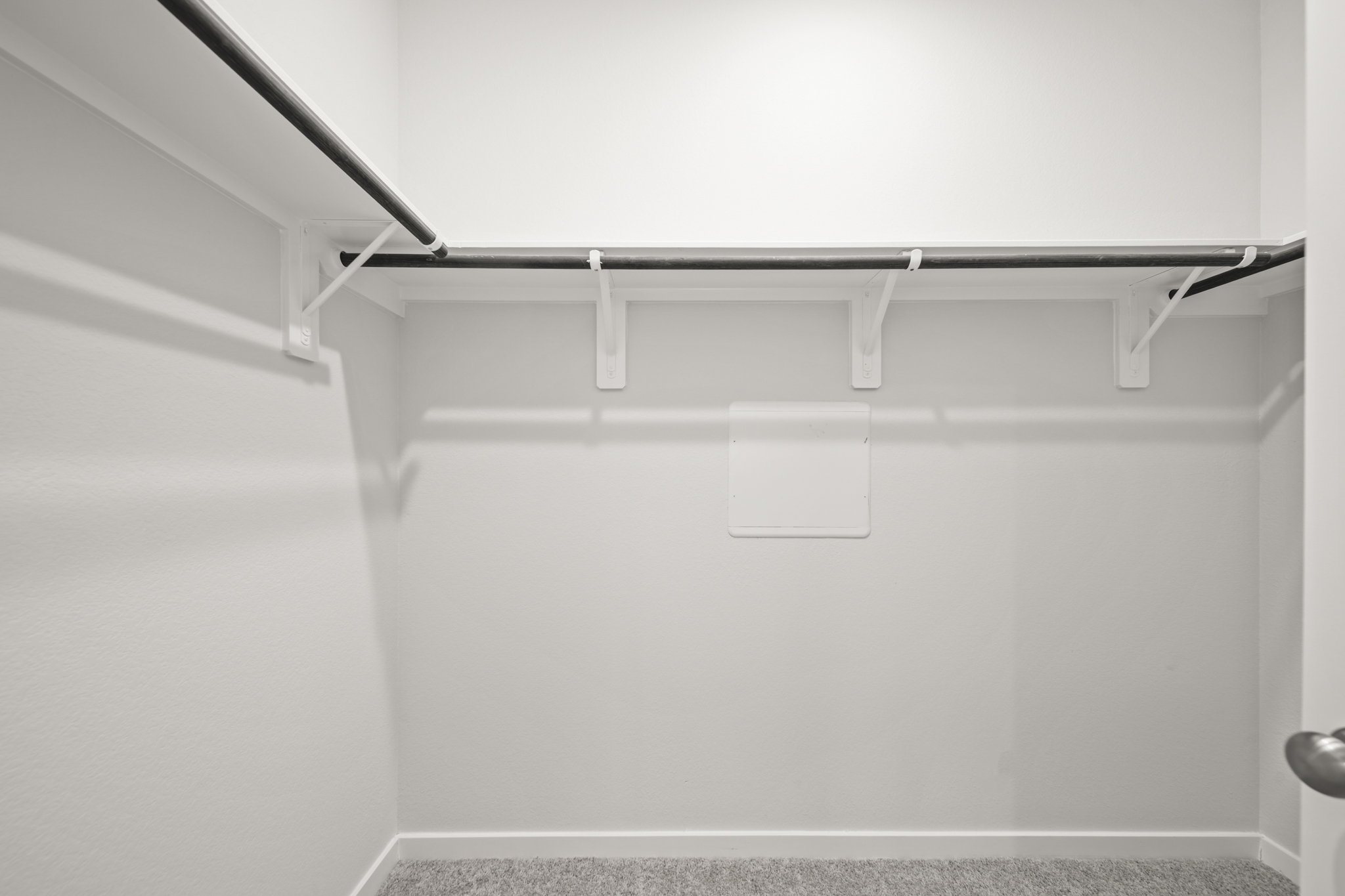 A white wall with a metal bar.