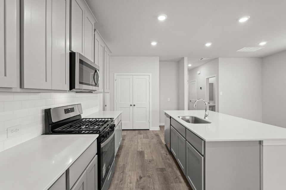 A kitchen with white cabinets.