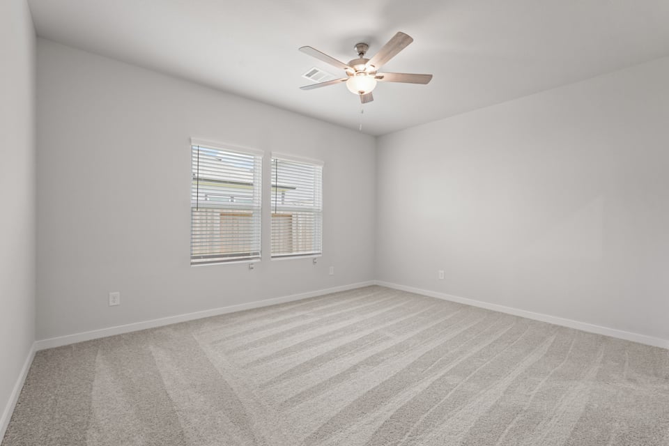 A room with a ceiling fan and a window.