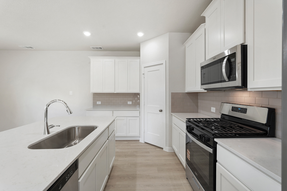 A kitchen with white cabinets.