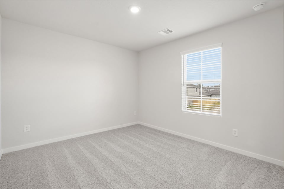 A room with a window and a carpet.