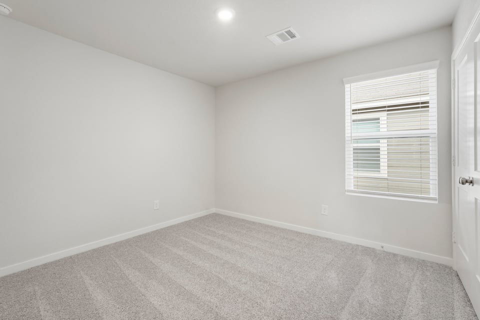 A room with a carpet and a window.