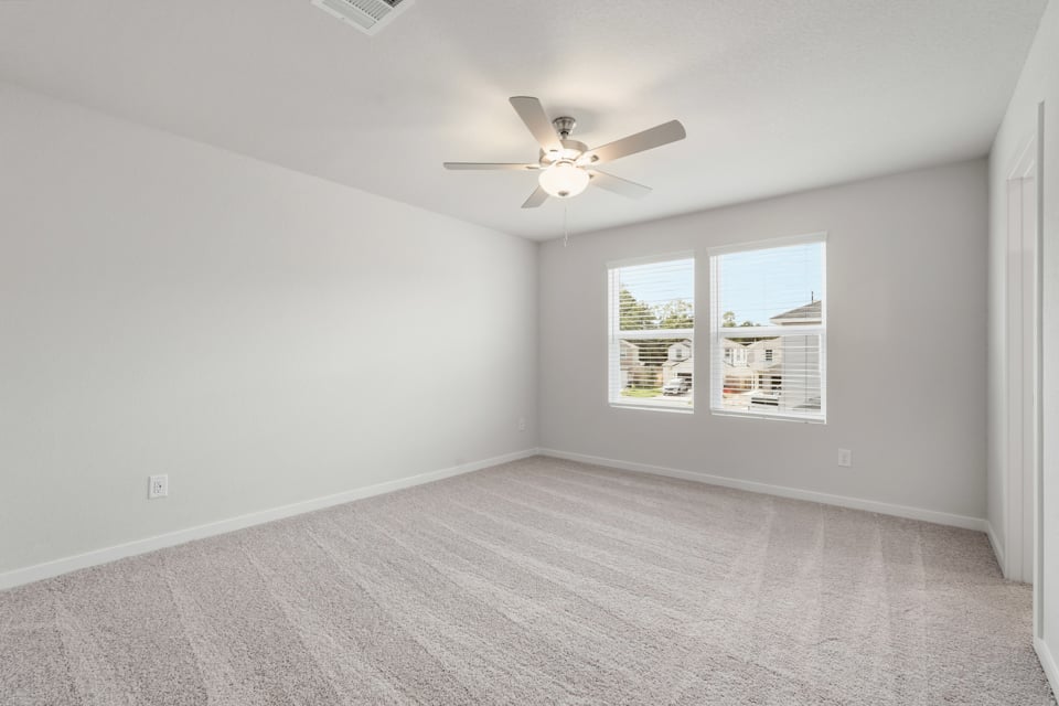A room with a ceiling fan and a window.