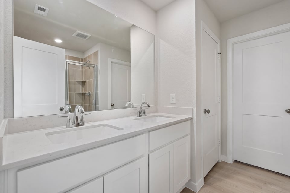 A bathroom with white cabinets.
